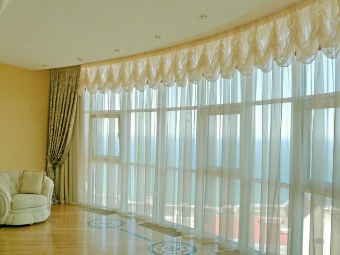 Панорамное окно в гостиной с французскими шторами