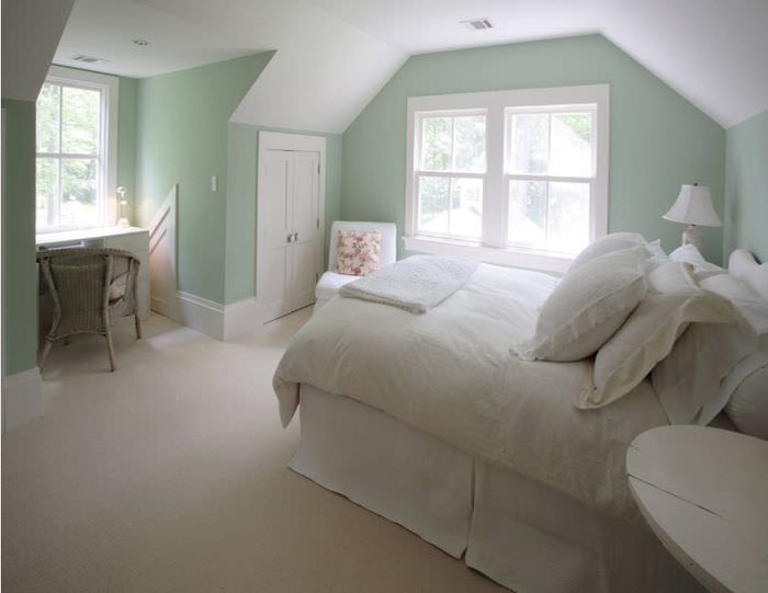 Белая кровать и мятные стены в спальне частного дома