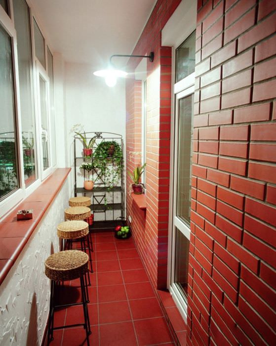 Красивый балкон с кирпичной стеной красного цвета