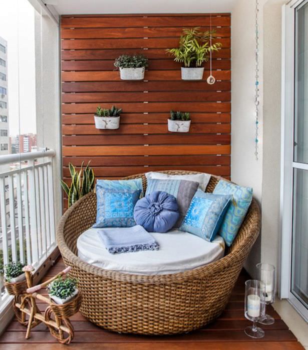 Плетенное кресло на деревянном полу открытого балкона
